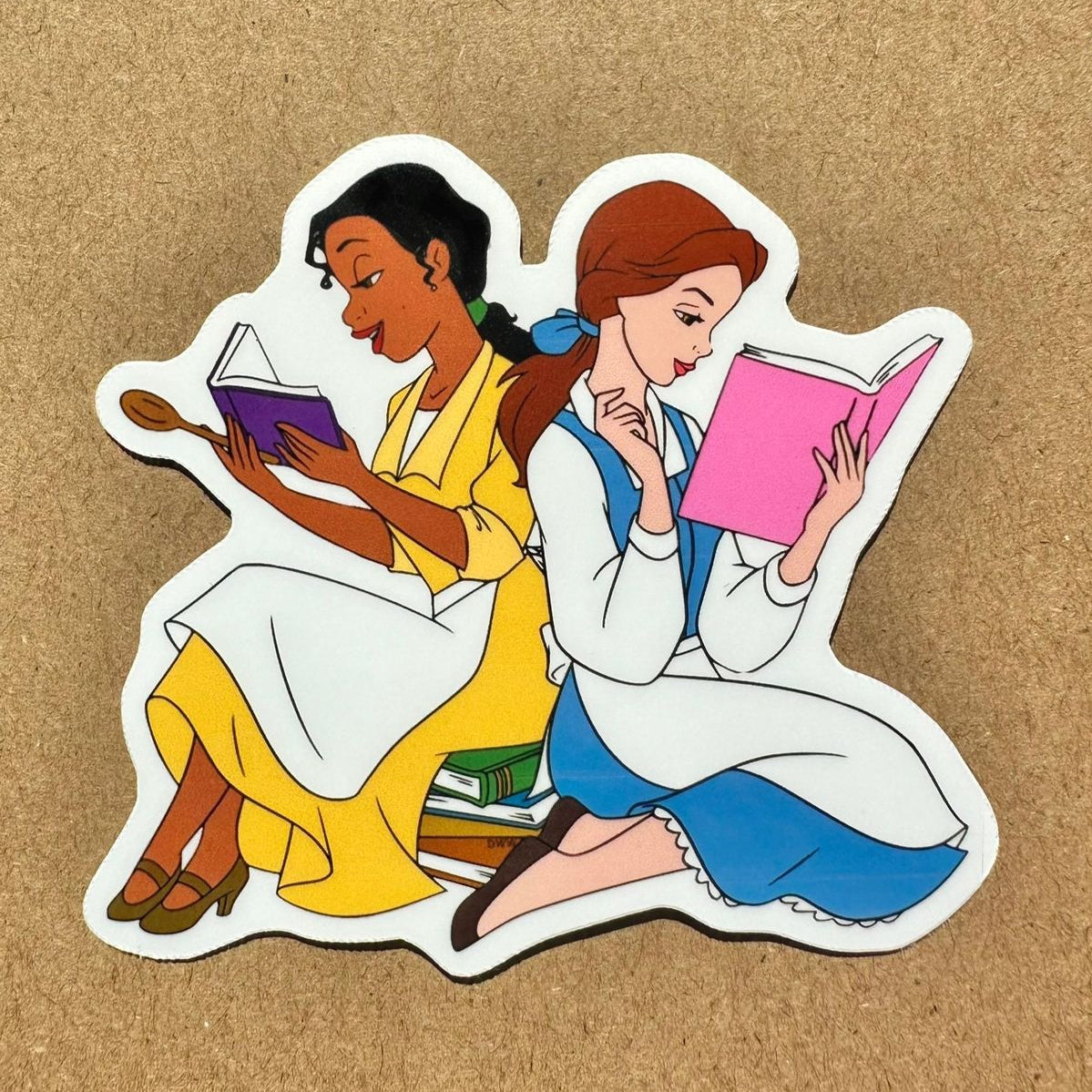 Illustration of two animated characters from disney. tiana is on the left and belle is on the right. they are reading books