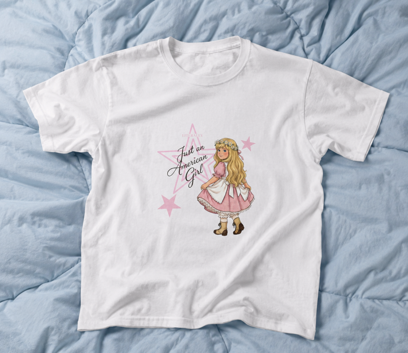 White coquette graphic tee with American girl inspired doll illustration on blue comforter