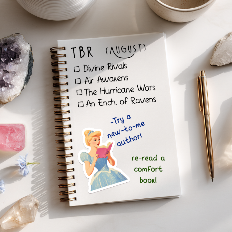 Notebook with TBR list, mug, flowers, and crystals on a light surface