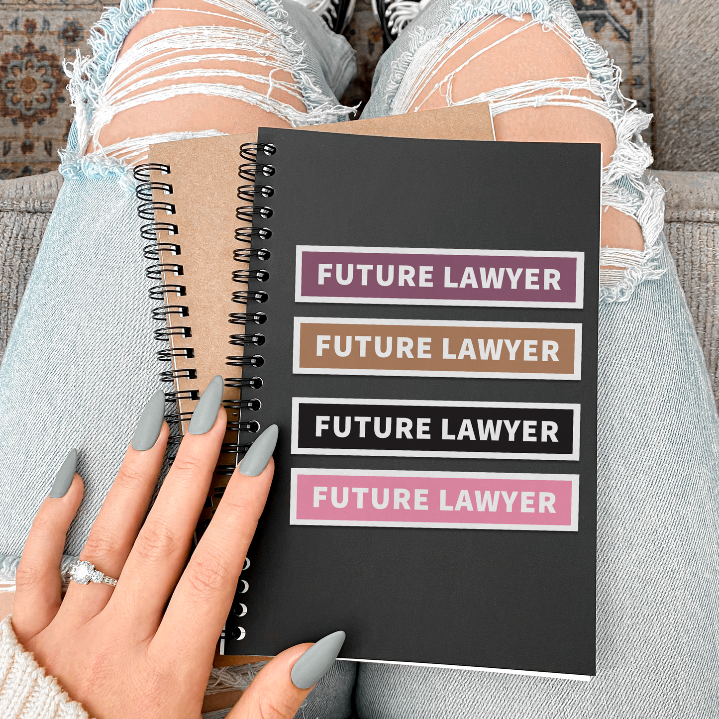 Person holding a notebook with 'Future Lawyer' text on a patterned rug.