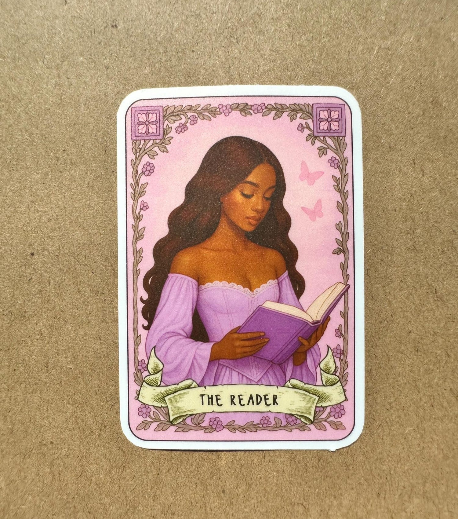 sticker featuring a woman reading a book with 'The Reader' text on a purple background